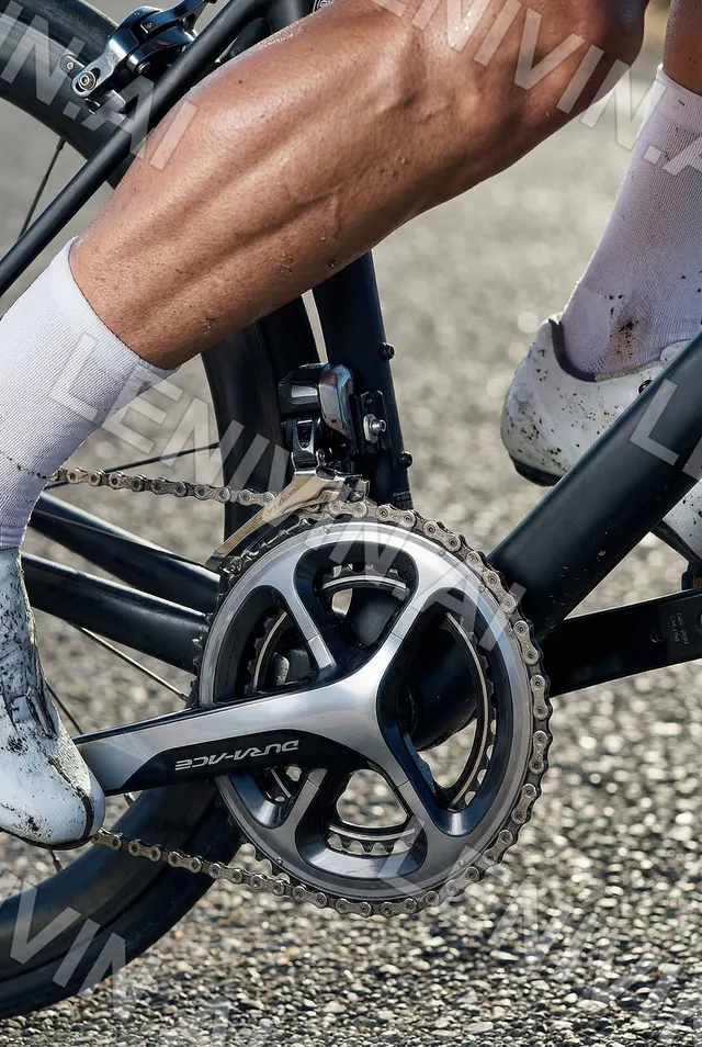 Крупный план велосипедной системы Shimano Dura-Ace и ноги в белой туфле