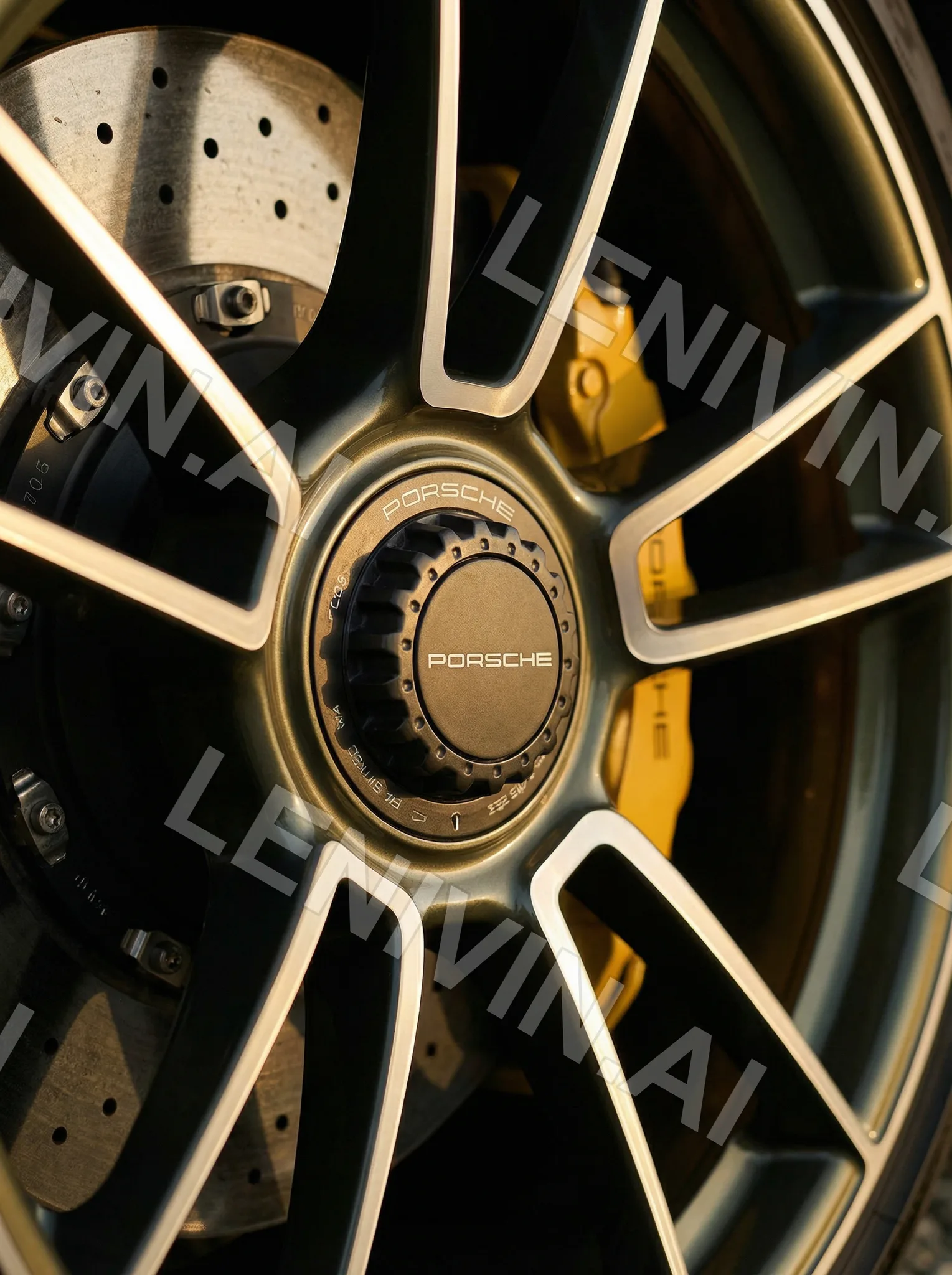 Крупный план колёсного диска Porsche с золотистой ступицей, жёлтый суппорт и перфорированный тормозной диск