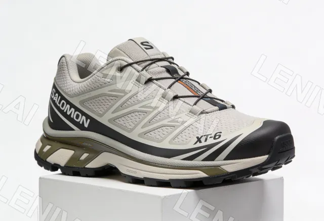 Бежево-серый кроссовок Salomon XT-6 на белом постаменте, студийный свет