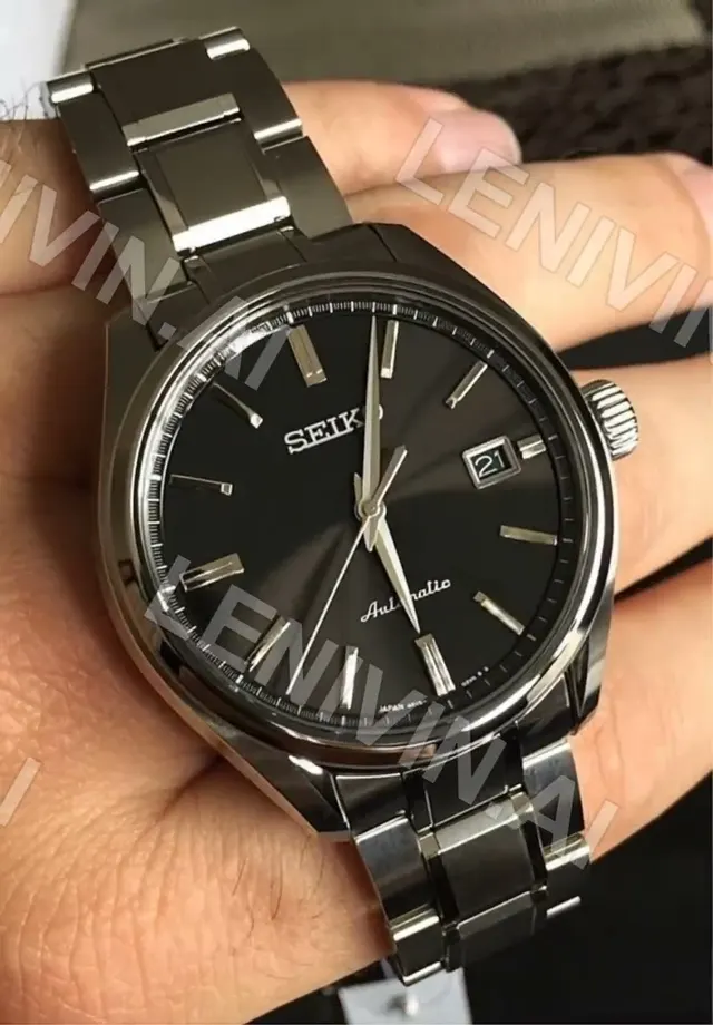 Ролик: стальной браслет часов Seiko с чёрным циферблатом крупно на ладони