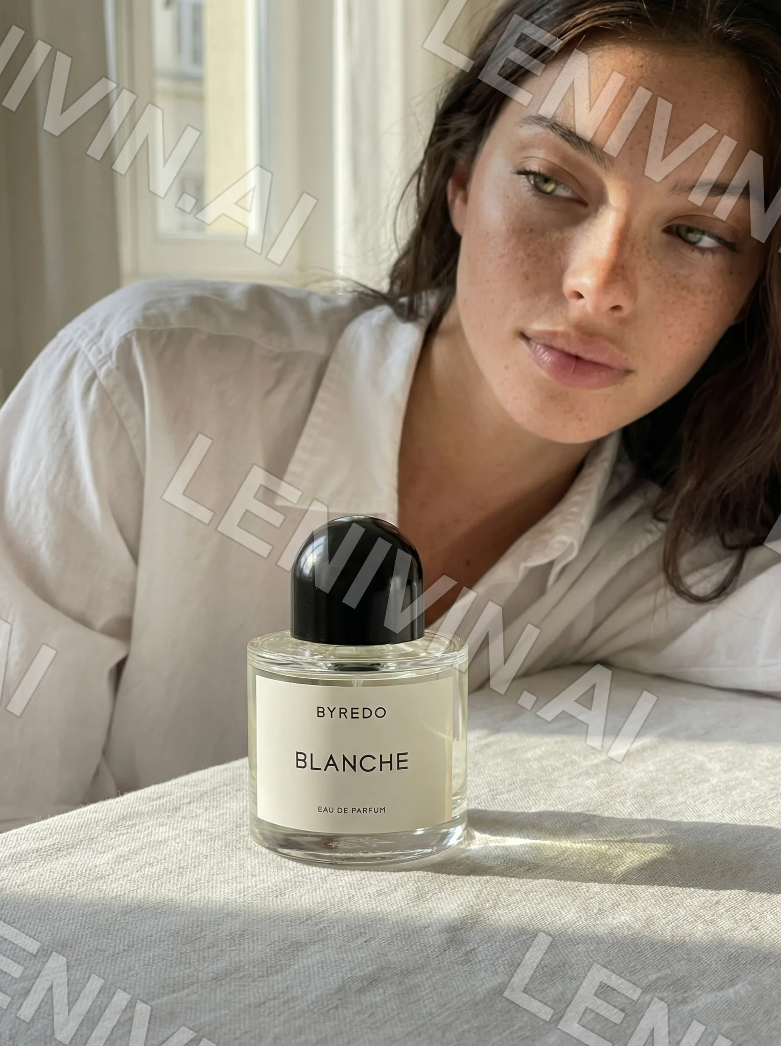 Брюнетка в белой рубашке у флакона Byredo Blanche на льняной ткани, взгляд в сторону