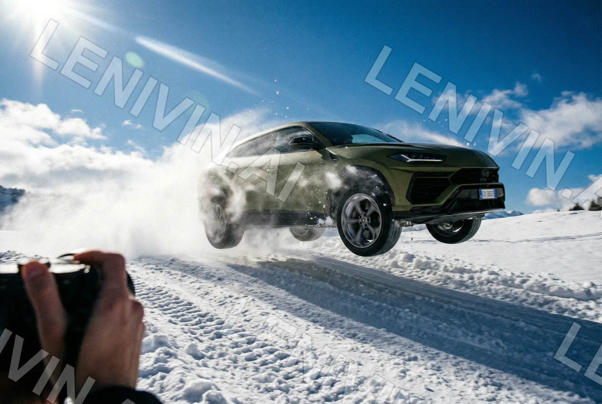 Зелёный Lamborghini Urus прыгает на снежной трассе, на переднем плане рука с камерой
