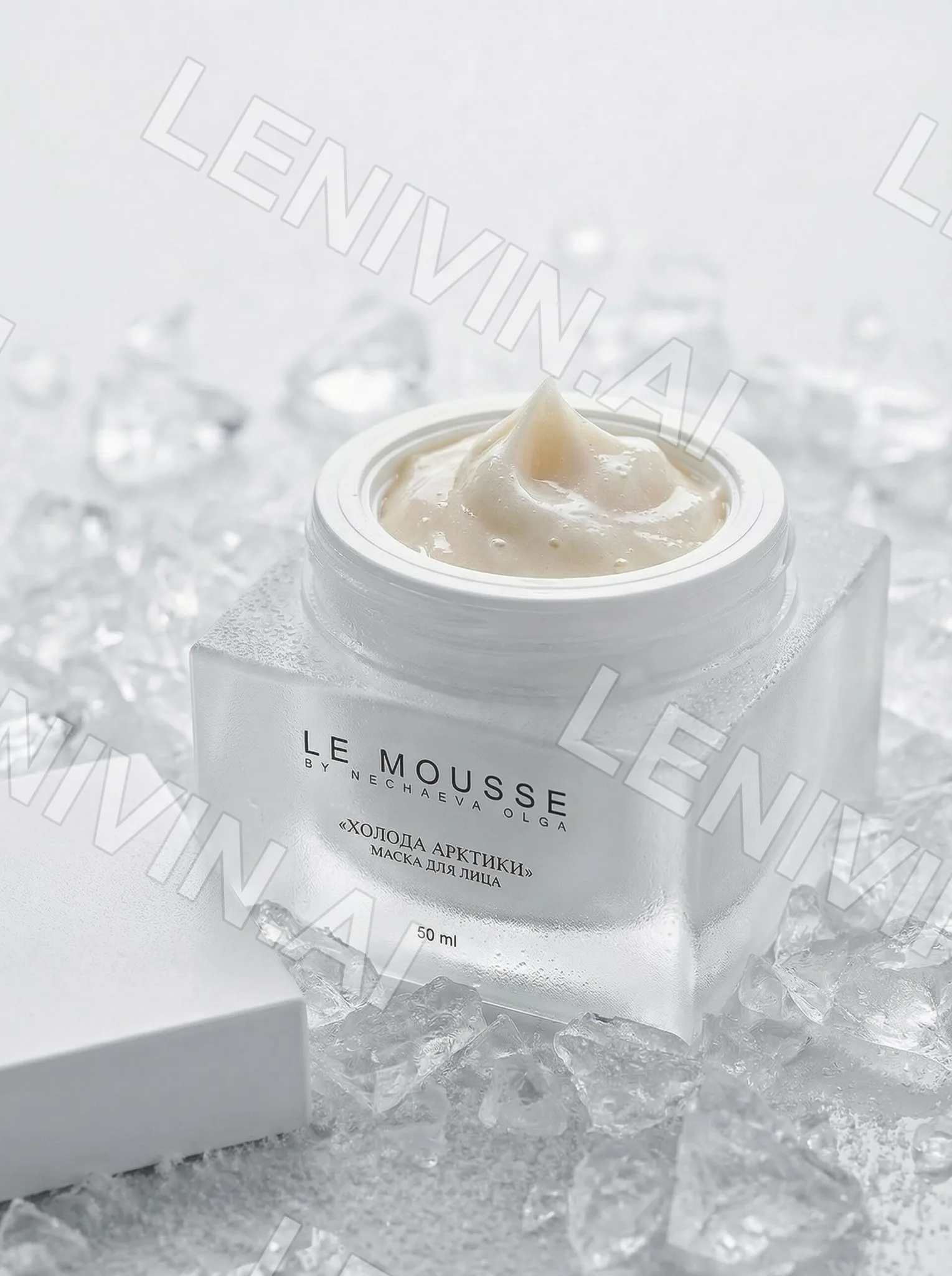 Открытая баночка крема Le Mousse с кремовой текстурой на белом кубе среди осколков льда