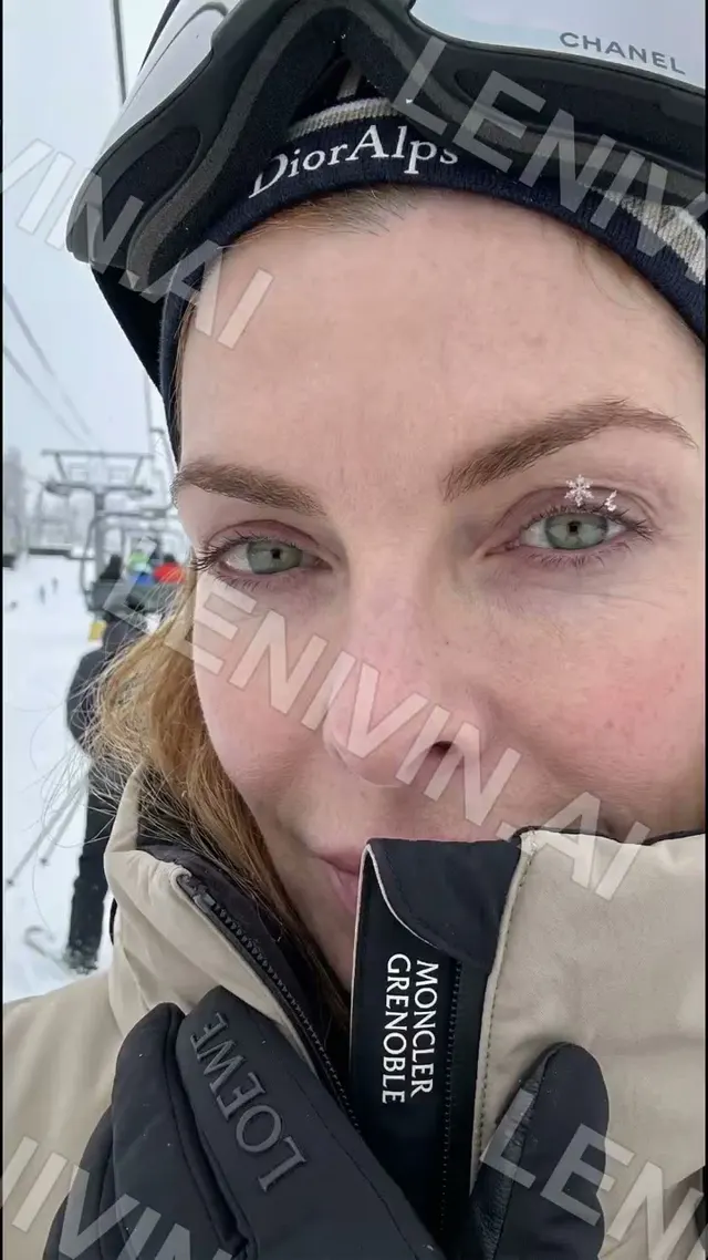 Ролик: селфи женщины в лыжной маске и шапке с надписью Dior, у лица воротник куртки, подъёмник на заднем плане